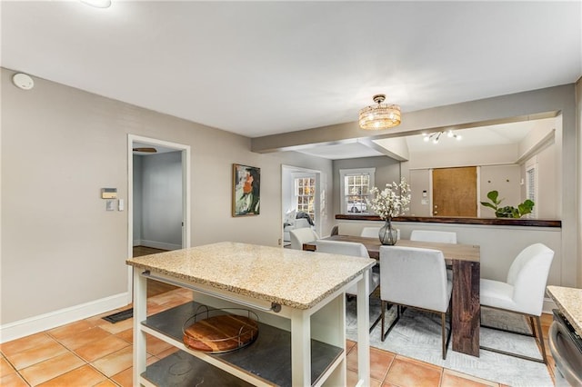 kitchen with light tile patterned floors, baseboards, dishwasher, light stone countertops, and open shelves