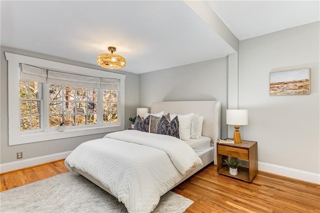 bedroom with wood finished floors and baseboards