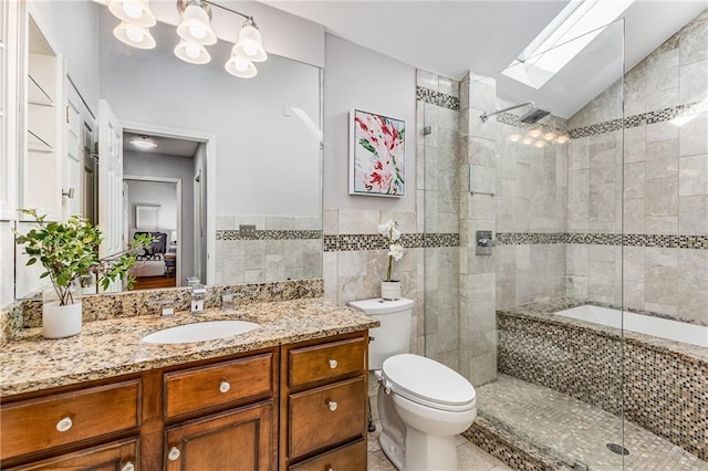 bathroom with toilet, lofted ceiling with skylight, a tile shower, and tile walls