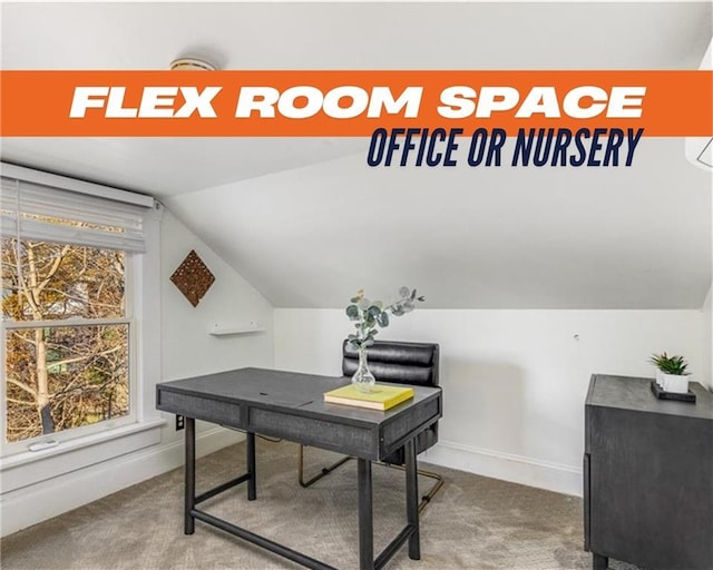 carpeted office space featuring vaulted ceiling and baseboards