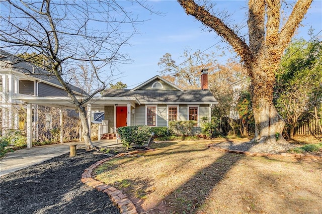 view of front of property featuring driveway and a chimney