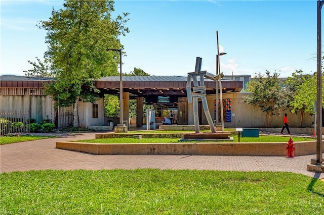 view of community featuring fence and a lawn