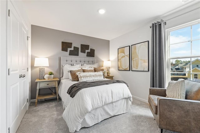 bedroom with baseboards and light carpet