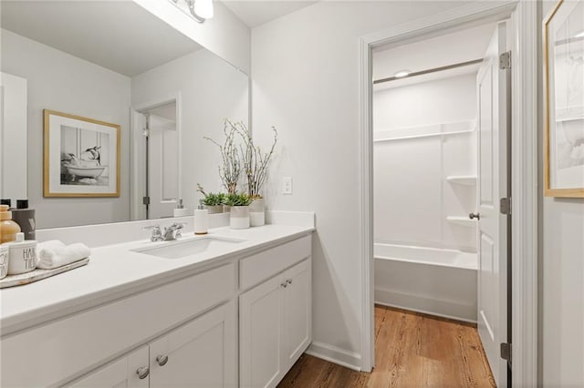 full bathroom with vanity, baseboards, and wood finished floors