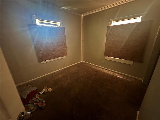 unfurnished room featuring baseboards, a healthy amount of sunlight, and crown molding