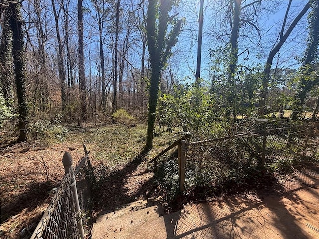 view of yard featuring fence and a view of trees