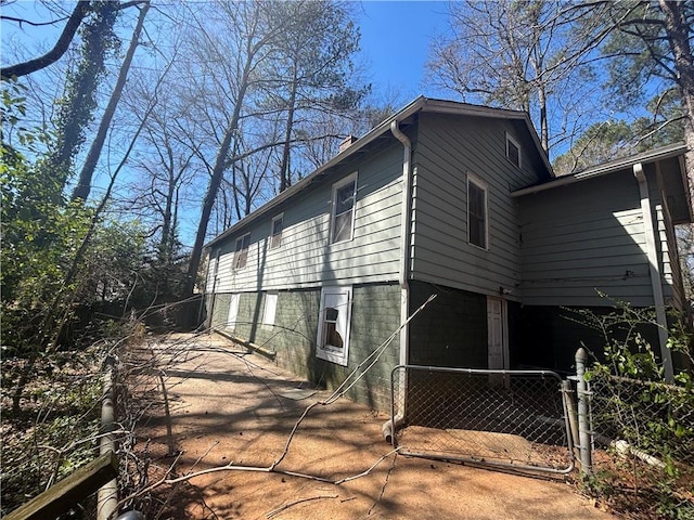 view of side of home with a gate and fence