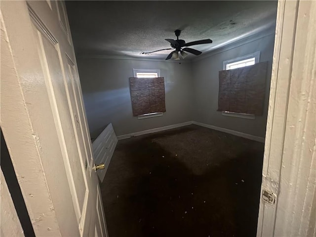 unfurnished room featuring ceiling fan, a textured ceiling, and baseboards