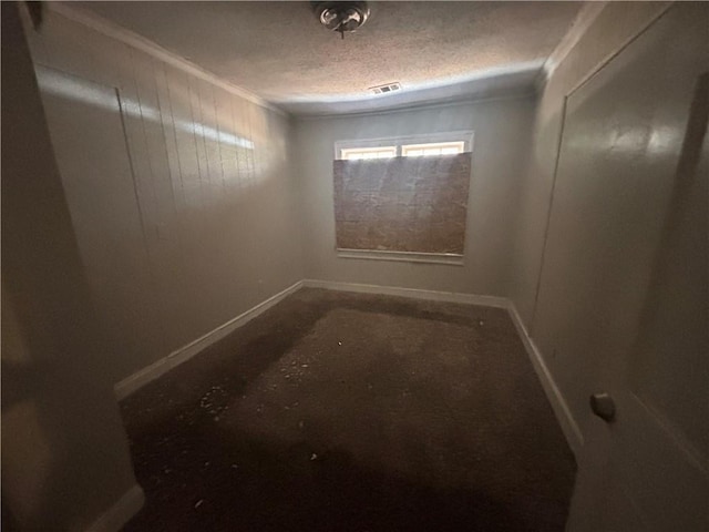 empty room with baseboards, visible vents, and a textured ceiling