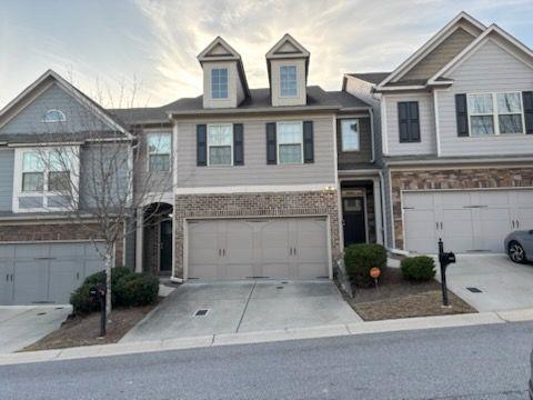 multi unit property featuring a garage, concrete driveway, and brick siding