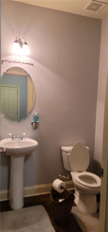 bathroom featuring baseboards, visible vents, a sink, and toilet