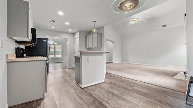 kitchen featuring visible vents, a ceiling fan, gray cabinets, light countertops, and light wood-style floors