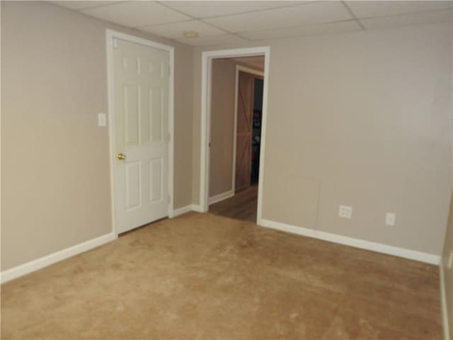 carpeted spare room with a paneled ceiling