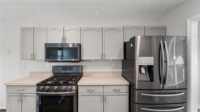 kitchen featuring appliances with stainless steel finishes, light countertops, and a textured ceiling