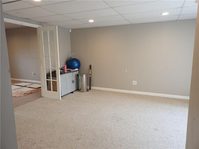 basement with a paneled ceiling and carpet floors