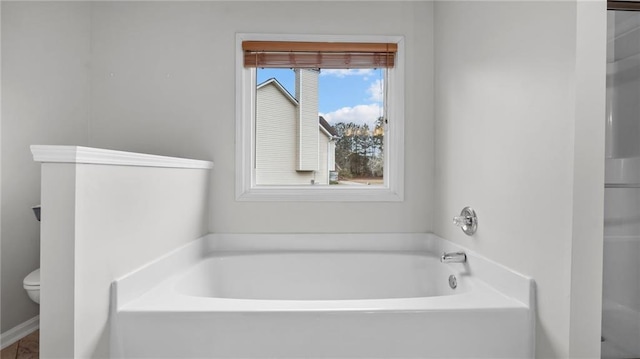 full bathroom featuring toilet and a bath