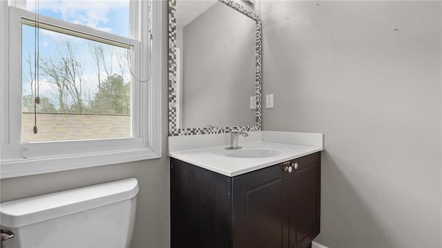 bathroom featuring a wealth of natural light, vanity, and toilet