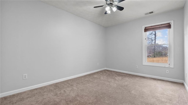 carpeted empty room featuring a ceiling fan, visible vents, and baseboards