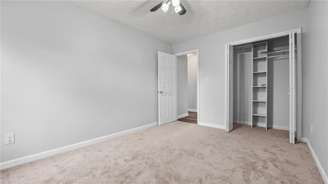 unfurnished bedroom with carpet, a closet, baseboards, and a ceiling fan