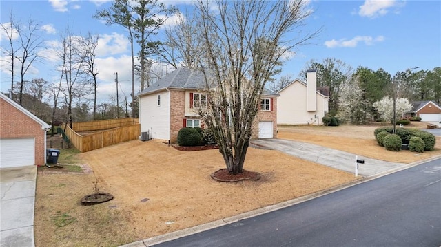 view of front facade with driveway, fence, cooling unit, and brick siding