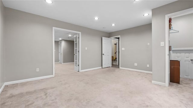 unfurnished bedroom with carpet, baseboards, a walk in closet, and recessed lighting