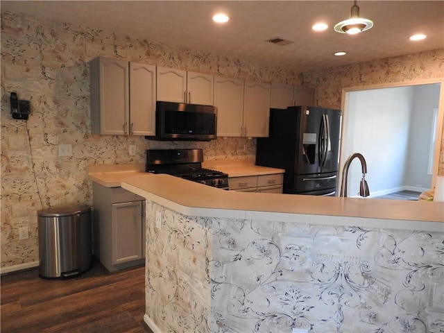 kitchen with dark wood-type flooring, sink, range with gas cooktop, black refrigerator with ice dispenser, and pendant lighting