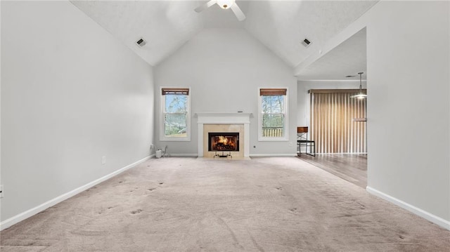 unfurnished living room featuring carpet, a high end fireplace, visible vents, and baseboards