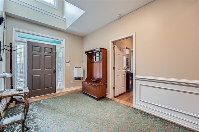 entrance foyer featuring light wood-type flooring and a skylight