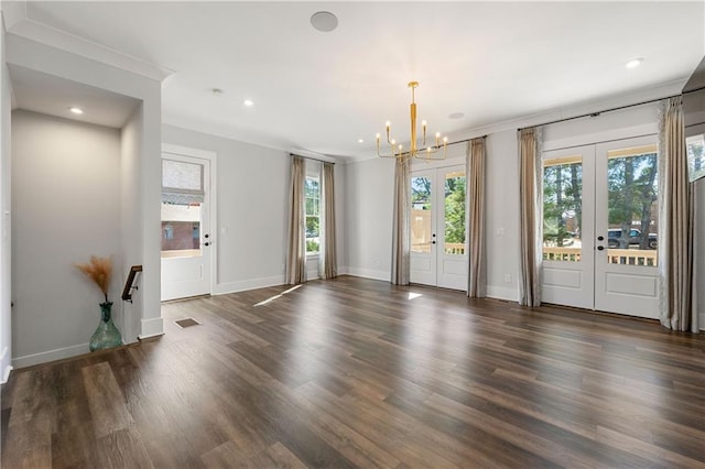 unfurnished room with ornamental molding, french doors, dark hardwood / wood-style floors, and a notable chandelier