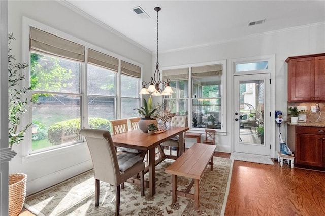 1771 Silvergrass Ln, Grayson, GA 30017 - dining area with crown molding, wood finished floors, healthy amount of natural light, and a chandelier