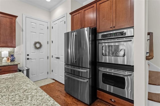 1771 Silvergrass Ln, Grayson, GA 30017 - kitchen with appliances with stainless steel finishes, ornamental molding, tasteful backsplash, wood finished floors, and light stone countertops