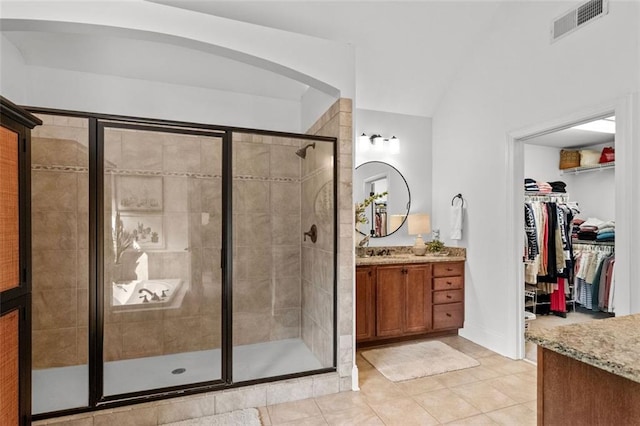 1771 Silvergrass Ln, Grayson, GA 30017 - bathroom featuring vanity, a shower stall, a walk in closet, and tile patterned flooring