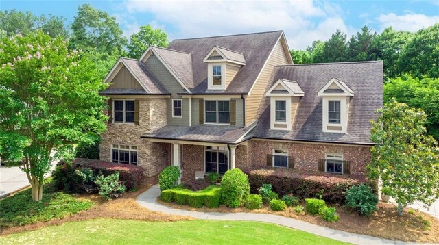 1771 Silvergrass Ln, Grayson, GA 30017 - view of front of home with stone siding, a front lawn, and a shingled roof