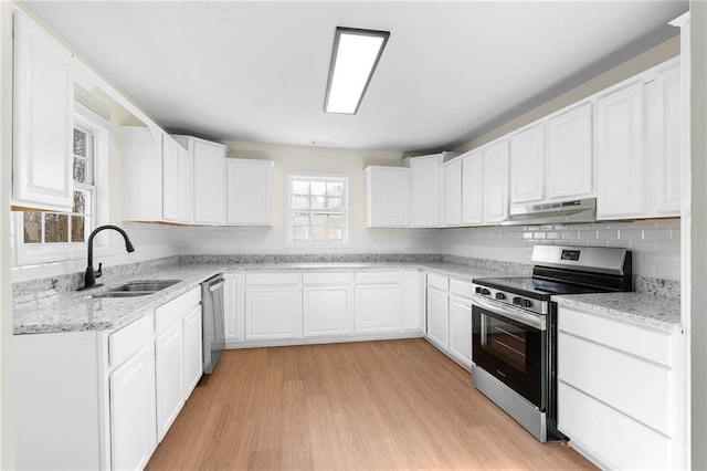 kitchen featuring light stone countertops, stainless steel appliances, light wood-type flooring, white cabinets, and sink