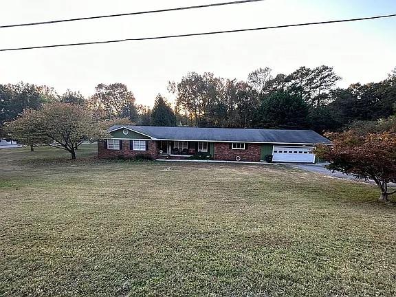 view of front of property featuring a garage and a front lawn