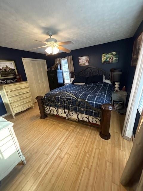 bedroom with ceiling fan, a textured ceiling, and light wood-type flooring