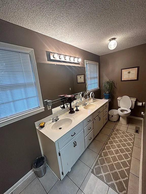 bathroom featuring vanity, plenty of natural light, tile patterned floors, and a textured ceiling