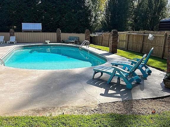 view of pool featuring a diving board and a patio area