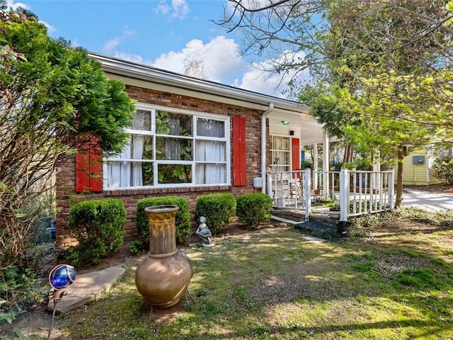view of front of home with brick siding and a porch