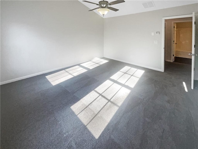 spare room with ceiling fan and dark carpet