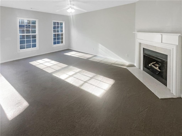 unfurnished living room with dark colored carpet and ceiling fan