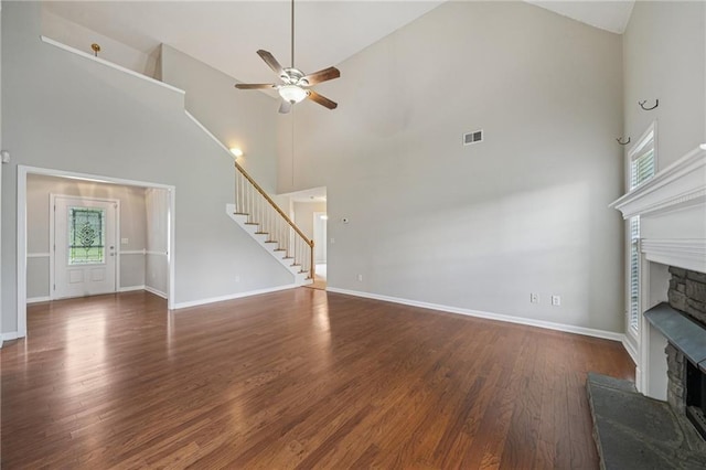 237 Raventree Ln, Griffin, GA 30224 - unfurnished living room featuring a stone fireplace, stairway, high vaulted ceiling, ceiling fan, and plenty of natural light