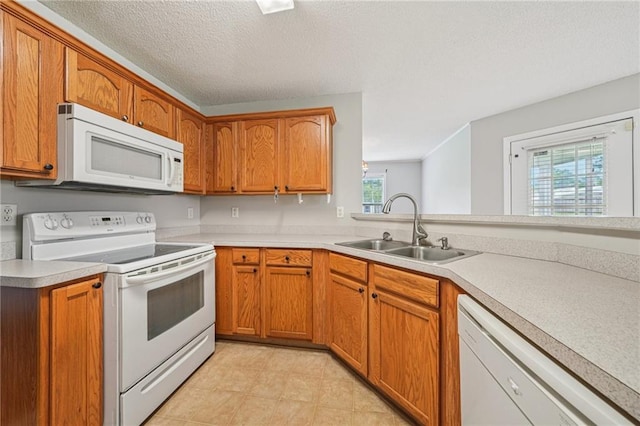 237 Raventree Ln, Griffin, GA 30224 - kitchen featuring white appliances, light countertops, brown cabinetry, light tile patterned flooring, and a textured ceiling