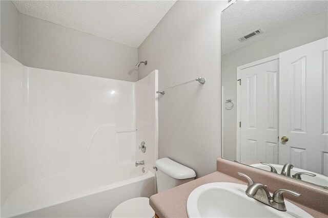 237 Raventree Ln, Griffin, GA 30224 - bathroom with a textured ceiling, vanity, and  shower combination
