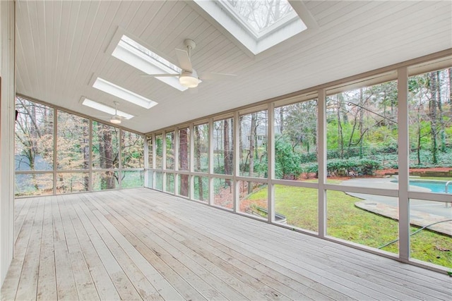 unfurnished sunroom featuring lofted ceiling, plenty of natural light, and ceiling fan