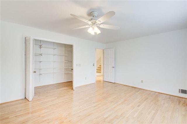 unfurnished bedroom featuring ceiling fan, light wood-type flooring, and a closet