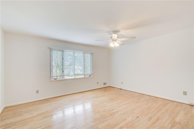 empty room with ceiling fan and light hardwood / wood-style flooring