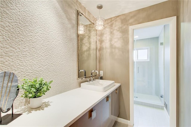 bathroom with a tile shower and vanity