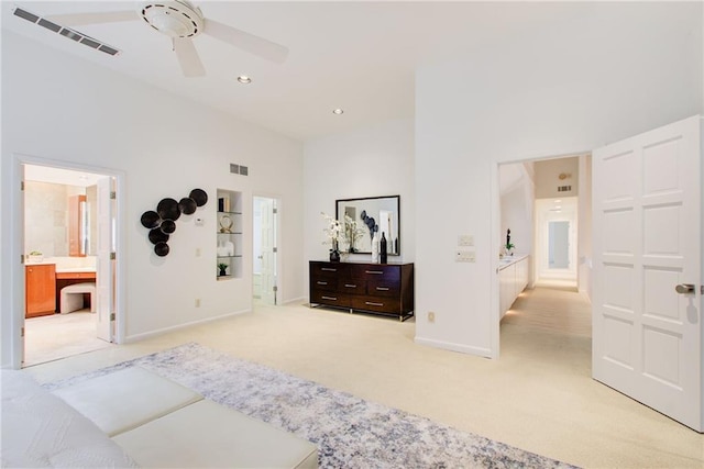 bedroom with light colored carpet, high vaulted ceiling, and ensuite bath