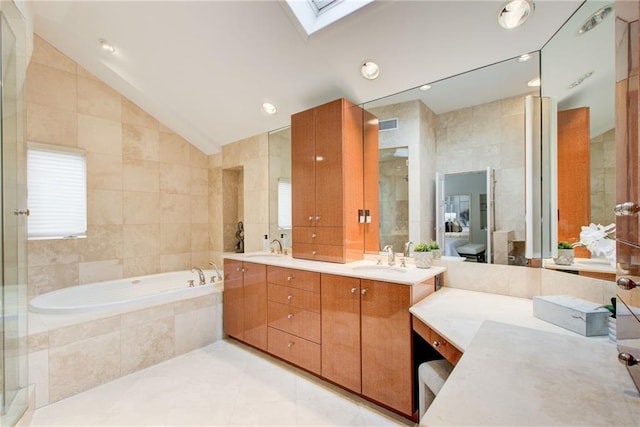 bathroom with plus walk in shower, vaulted ceiling with skylight, tile walls, vanity, and tile patterned floors